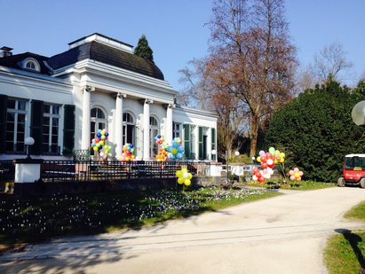 Die Villa Leonhardi ist mit vielen bunten Luftballons im Vordergrund dekoriert.